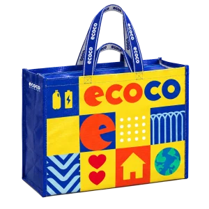 ECOCO 再生循環袋正面，藍色袋身配黃色格紋拼貼，印有 ecoco 字樣、寶特瓶、愛心、房子與地球圖案，雙提帶